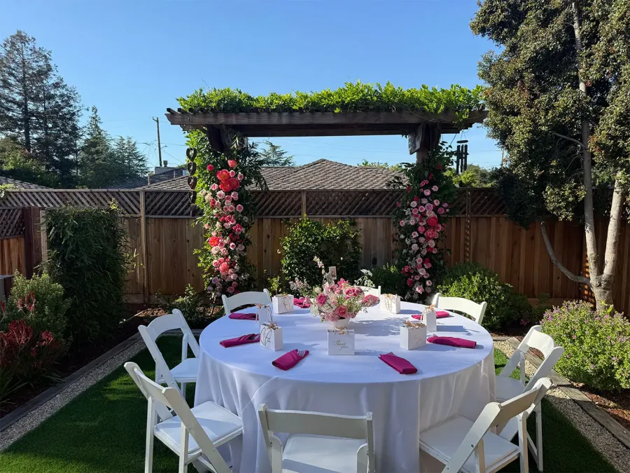In-house floral arch of garden roses and eucalyptus framing a ceremony space at a Napa estate wedding by Napa Catering Company