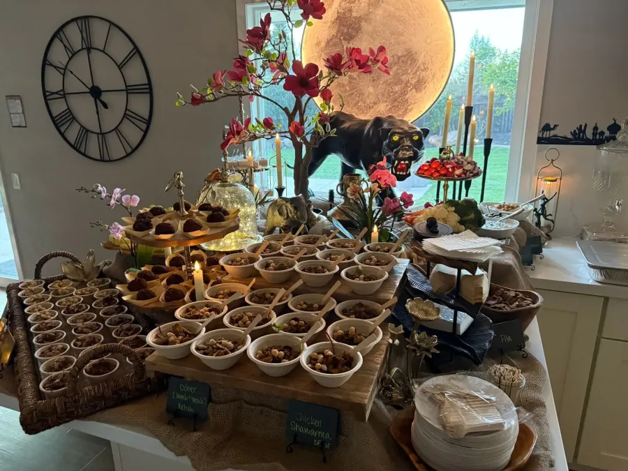 Mediterranean buffet of shawarma chicken, kebob and mezze framed by low seasonal arrangements — floral accents for Benicia catering dinners